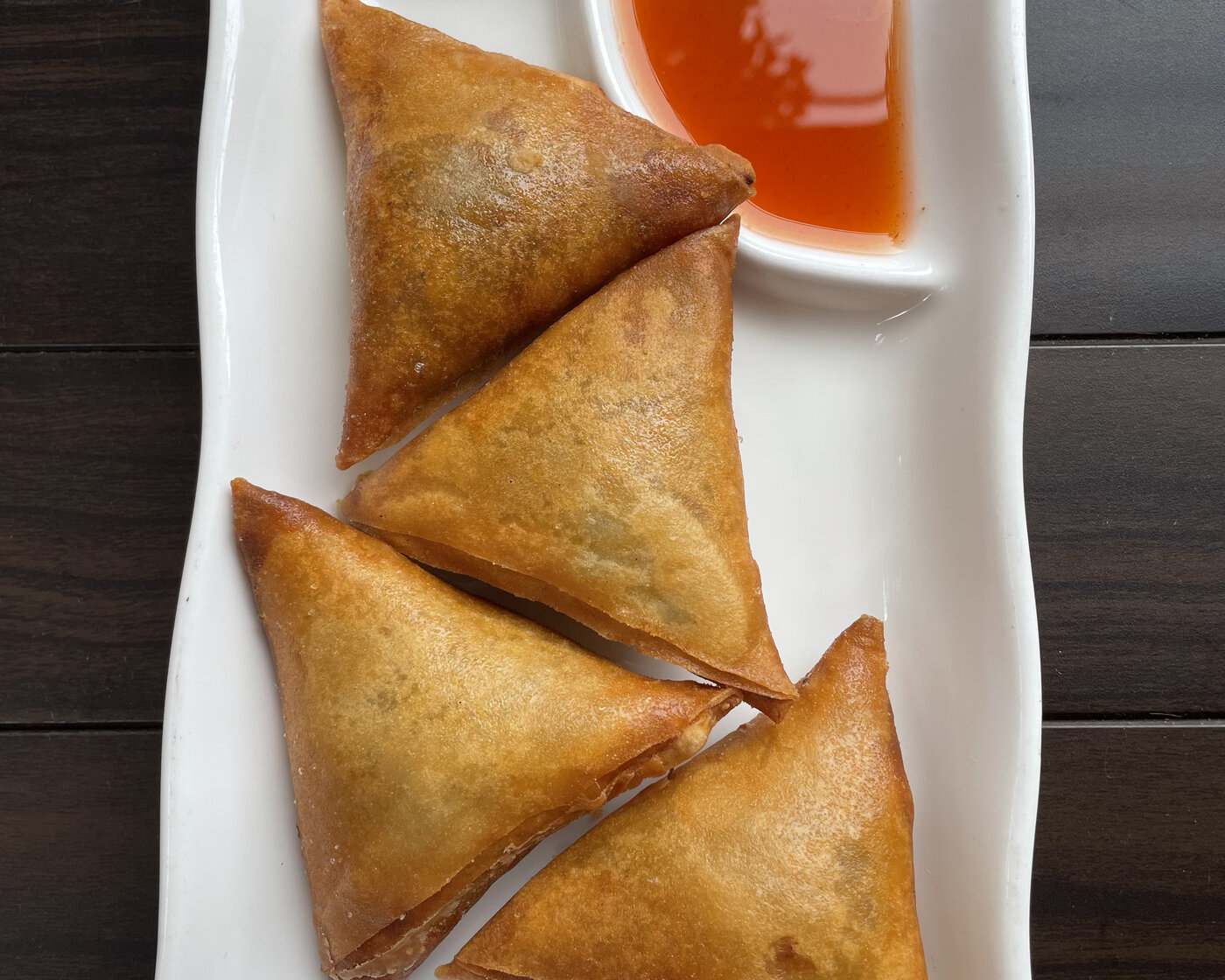 Vegetarian samusa, crisp curry puffs served with a sweet chili dipping sauce